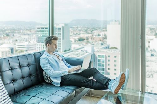 Man with a computer sitting in an office.